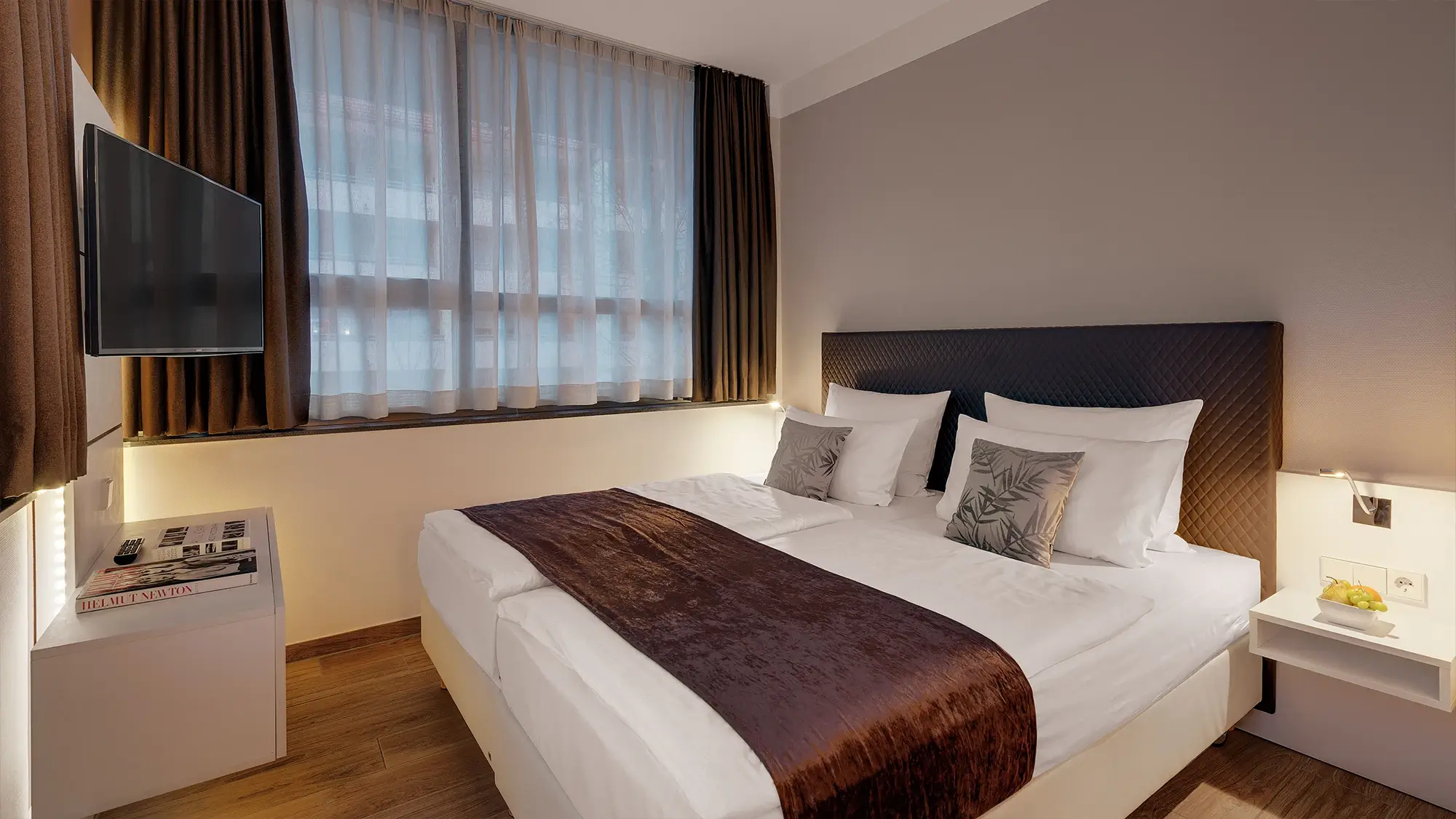 Helles Schlafzimmer mit großem Fenster und komfortablem Doppelbett